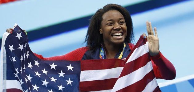 Gold medallist USA's Simone Manuel wave her national flag during the medal ceremony of the Women's 100m Freestyle Final during the swimming event at the Rio 2016 Olympic Games at the Olympic Aquatics Stadium in Rio de Janeiro on August 11, 2016. (Photo credit:ODD ANDERSEN/AFP/Getty Images)